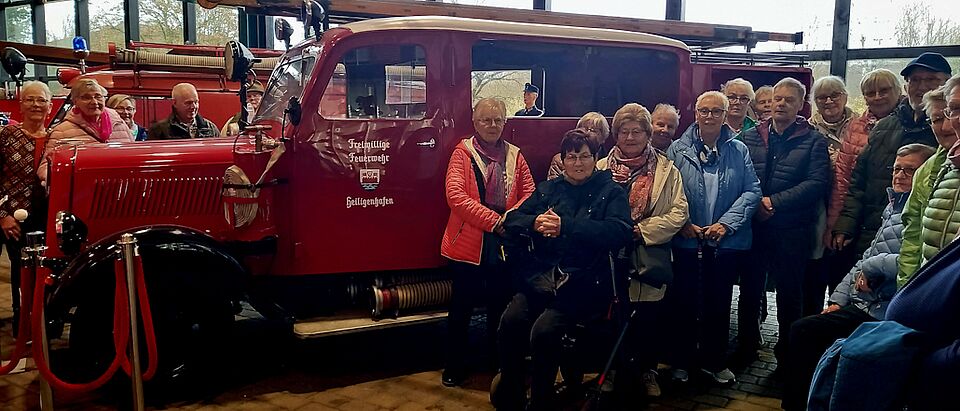 Reisegruppe mit historischem Feuerwehrfahrzeug