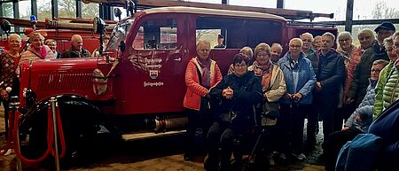Reisegruppe mit historischem Feuerwehrfahrzeug